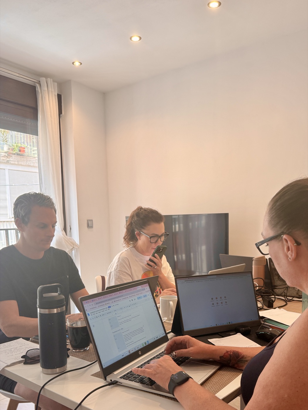 Attendees working on laptops around the table during an implementation day